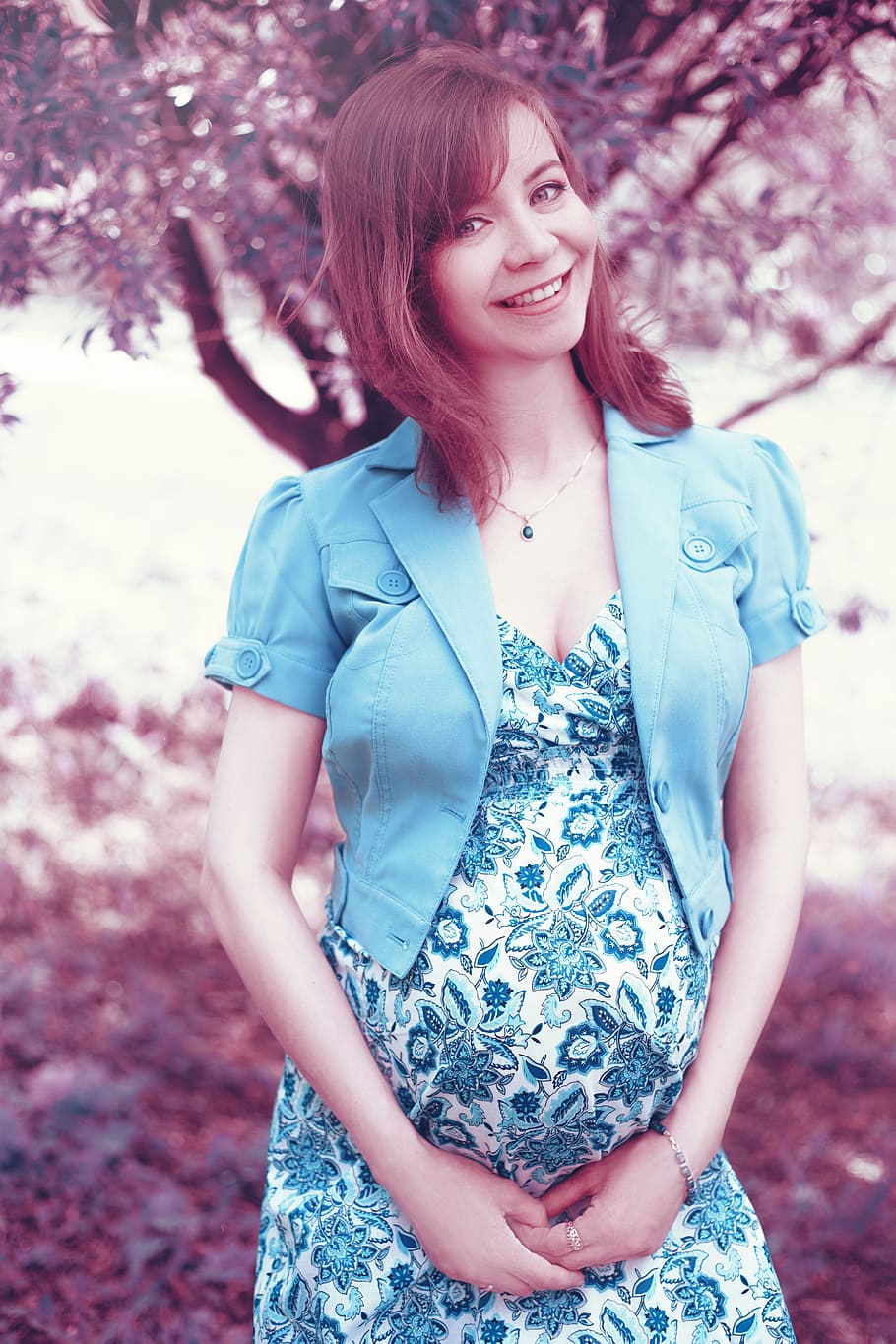 smiling, woman, wearing, blue, floral, dress, pregnant, pregnancy, mom, park