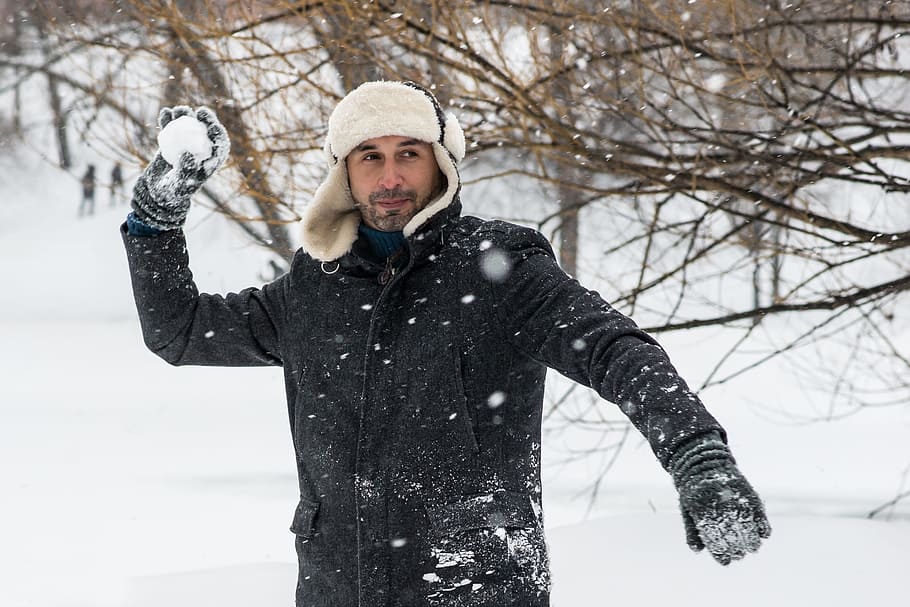 man playing snowball, winter, snow, the snow falls, snowballs, winter games, man, hat, fur coat, coldly