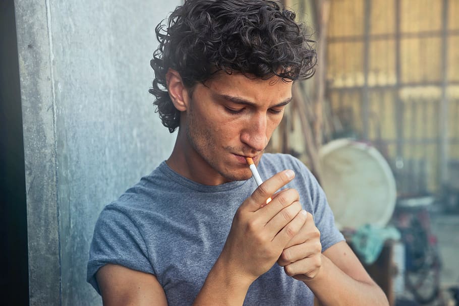 man, lighting, cigarette, smoke, male, people, one person, focus on foreground, looking, holding
