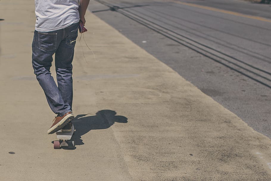 homem, montando, skate, branco, camisa, azul, jeans, patinador, andar de skate, rua