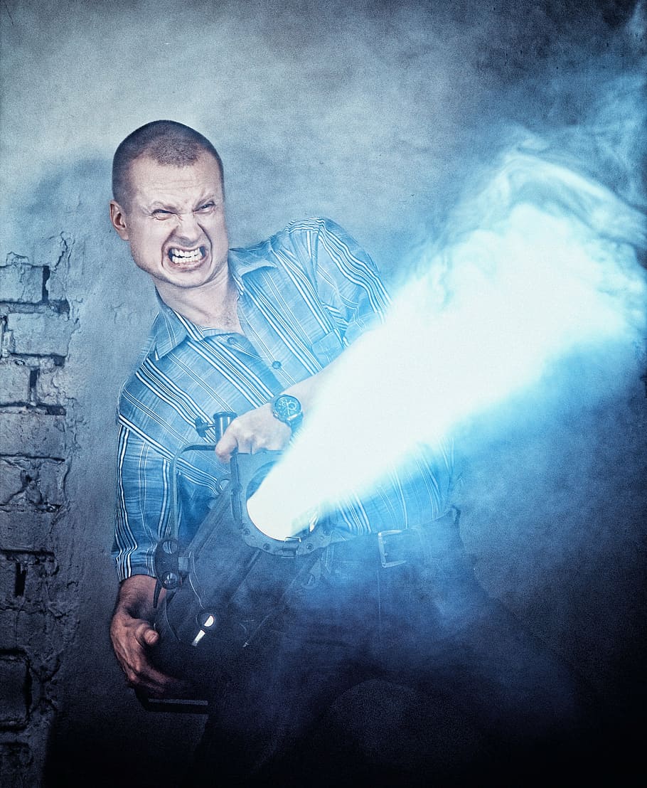 man, holding, force air heater, wall, grin, teeth, person, portrait, attack, brick