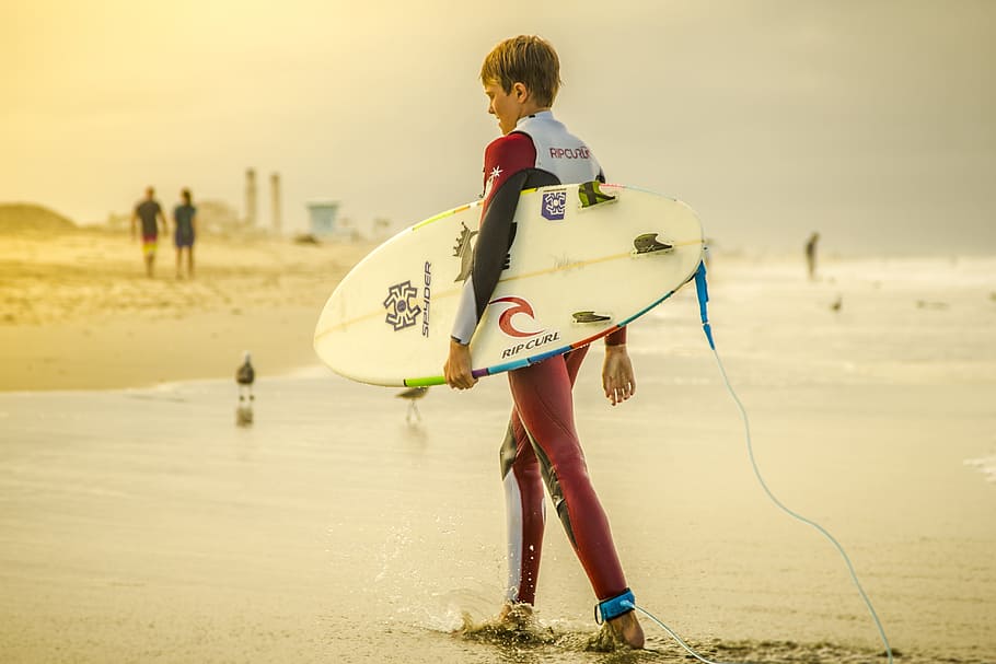 person, holding, skimboard, standing, sand, surfer, surfboard, surfing, boy, sports