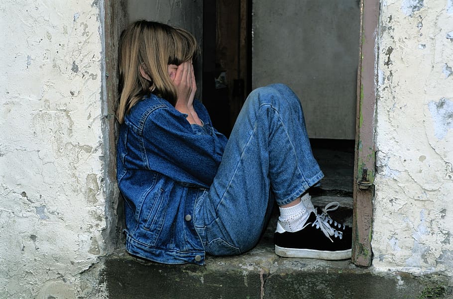 menina, azul, jeans, jaqueta jeans, preto, tênis, cobrindo, rosto, criança sentada, na porta