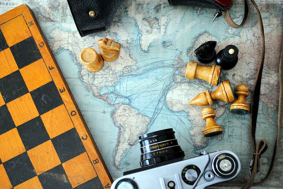 slr camera, chess board, chess, camera, world map, indoors, close-up, day, high angle view, map