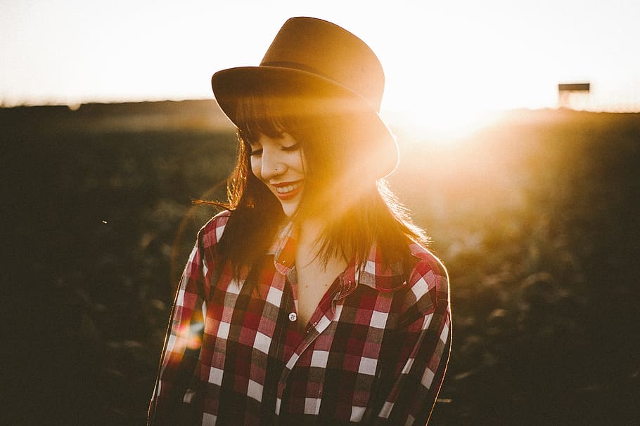 smiling, woman, wearing, red, white, black, checked, button-up dress shirt, brown, fedora hat