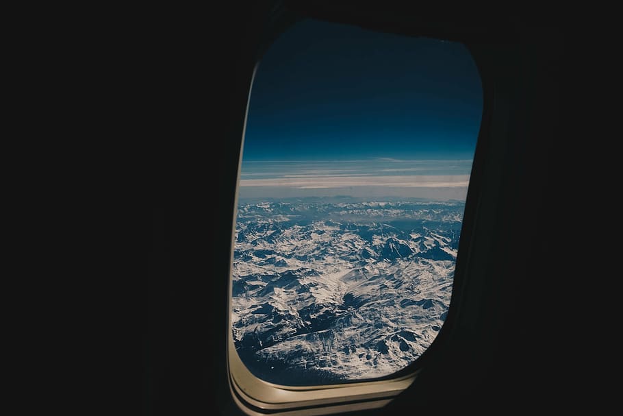 person, taking, airplane window, viewing, mountains, covered, snow, airplane, airline, travel