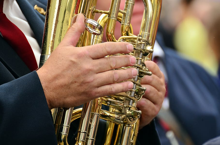 person, playing, gold wind instrument, hands, musical instrument, tuba, brass band, brass instrument, wind instrument, blowers
