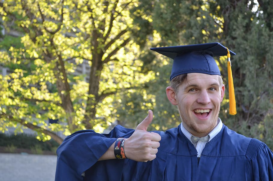 hombre, birrete, académico, vestido, mostrando, pulgares, signo, graduación, gorra, bata