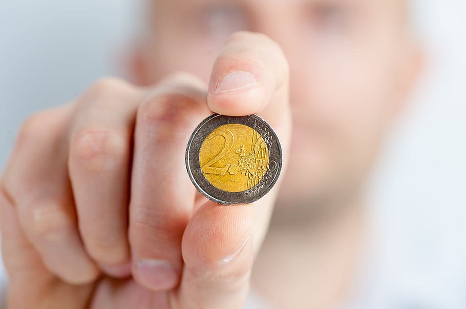 person, holding, round silver, gold-colored 2 coin, coin, coins, money, savings, a wealth of, rich