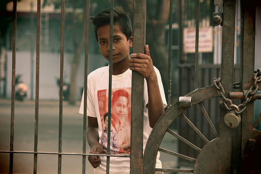 boy, holding, brown, metal gate, poor, young, child, person, asian, indian