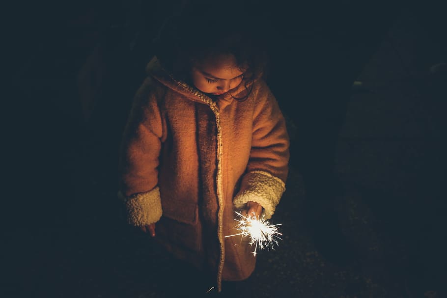 girl, brown, coat, holding, lighted, sparkler, nighttime, child, celebration, light