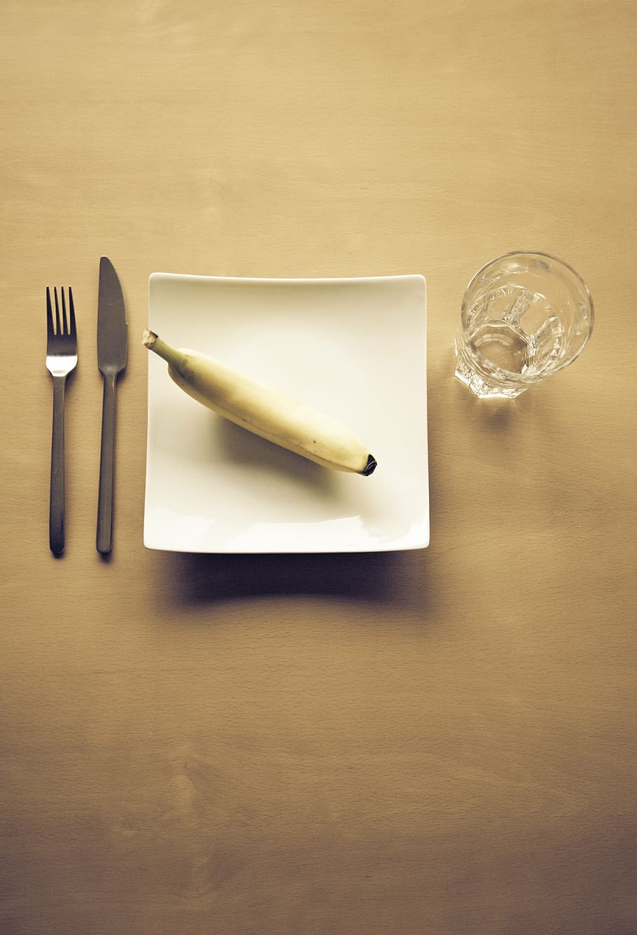 clear, rock glass, white, ceramic, plate, banana, top, fork, knife, drinking