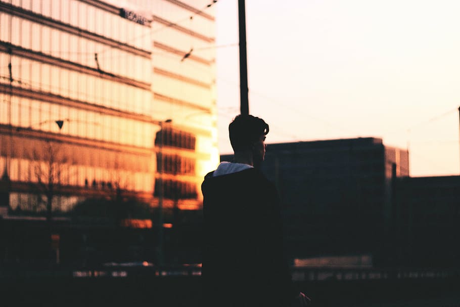 superficial, fotografía de enfoque, hombre, negro, camisa, en pie, al lado, edificio, puesta de sol, anochecer
