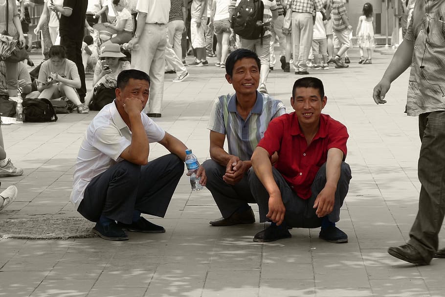 tiga, pria, berjongkok, trotoar, orang-orang, Cina, bahagia, jongkok, melihat kamera, potret