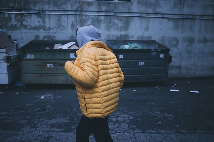low, light photography, person, wearing, yellow, bubble jacket, standing, garbage bins, alleyway, dumpsters