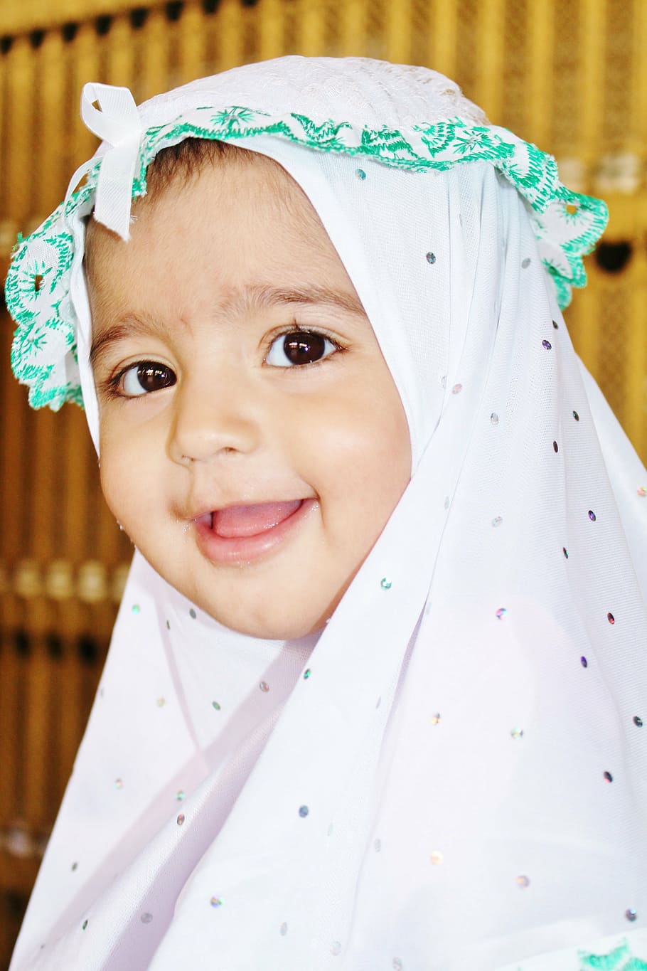 sonriente, bebé, vistiendo, blanco, negro, tocado de lunares, musulmán, niña, bufanda, islam