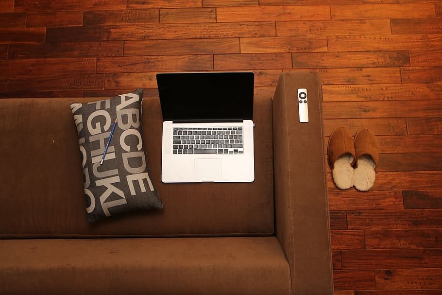 macbook, laptop, apple, remote, sofa, couch, pillow, pencil, slippers, hardwood