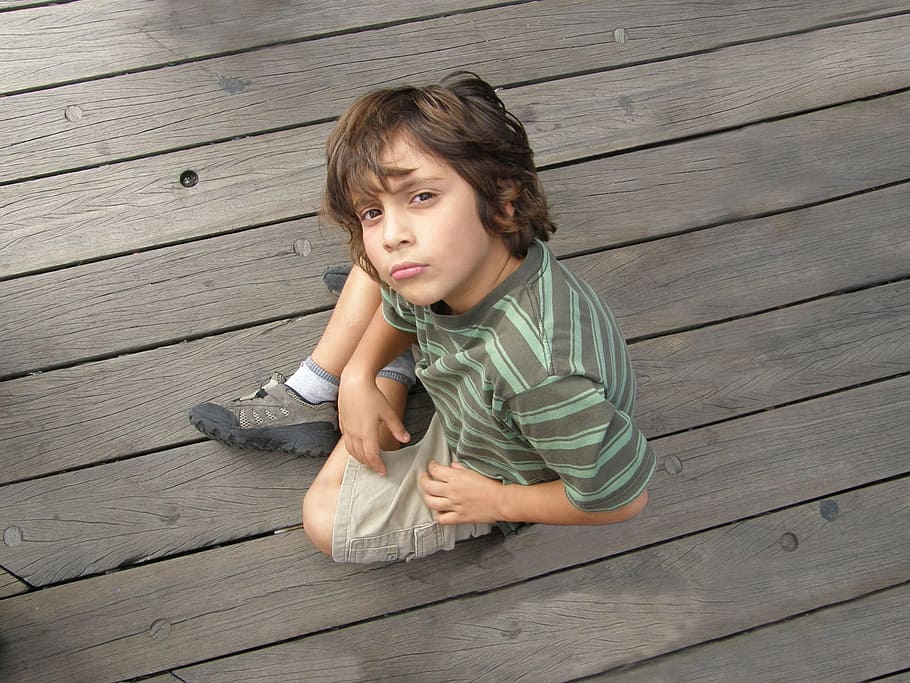 boy, wearing, striped, printed, shirt, brown, cargo pants, sitting, parquet floor, look