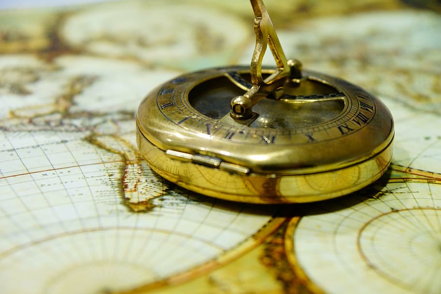 round gold-colored pocket, watch, compass, antique, map of the world, navigation, route, north, west, south