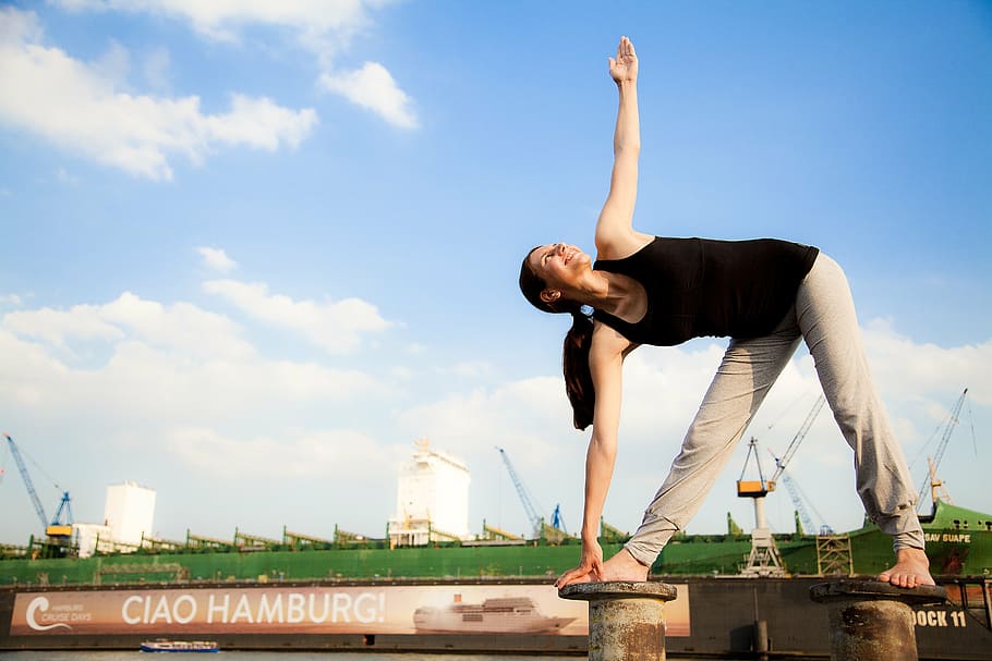 woman, holding, foot, exercising, gray, metal bar, daytime, yoga, port, hamburg