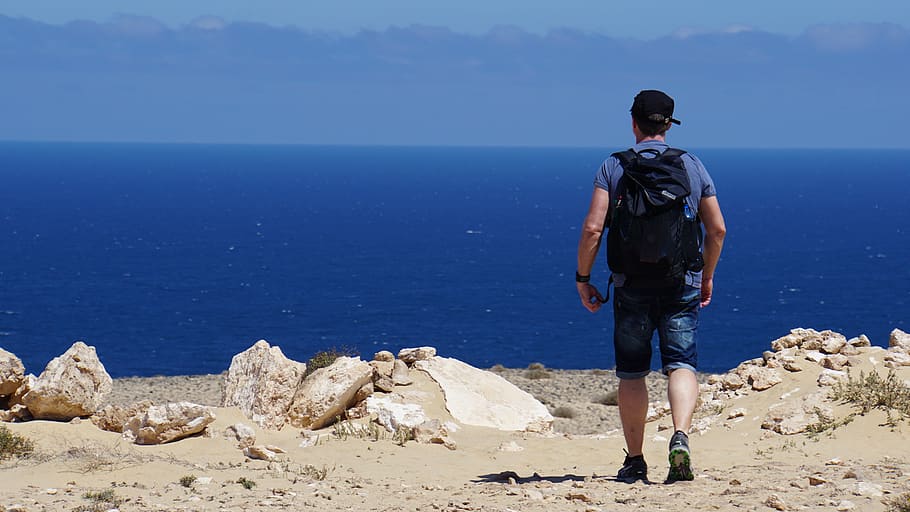 man, hiking, backpack, sea, ocean, blue, rock, fuerteventura, island, nature reserve