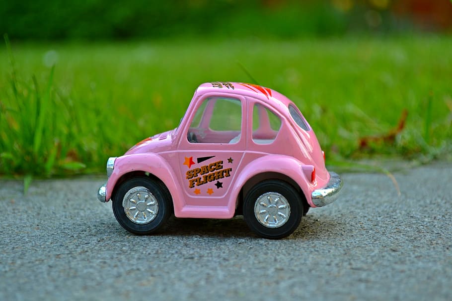 close-up photography, pink, car toy, green, grass field, car, miniature, miniature car, nature, green grass