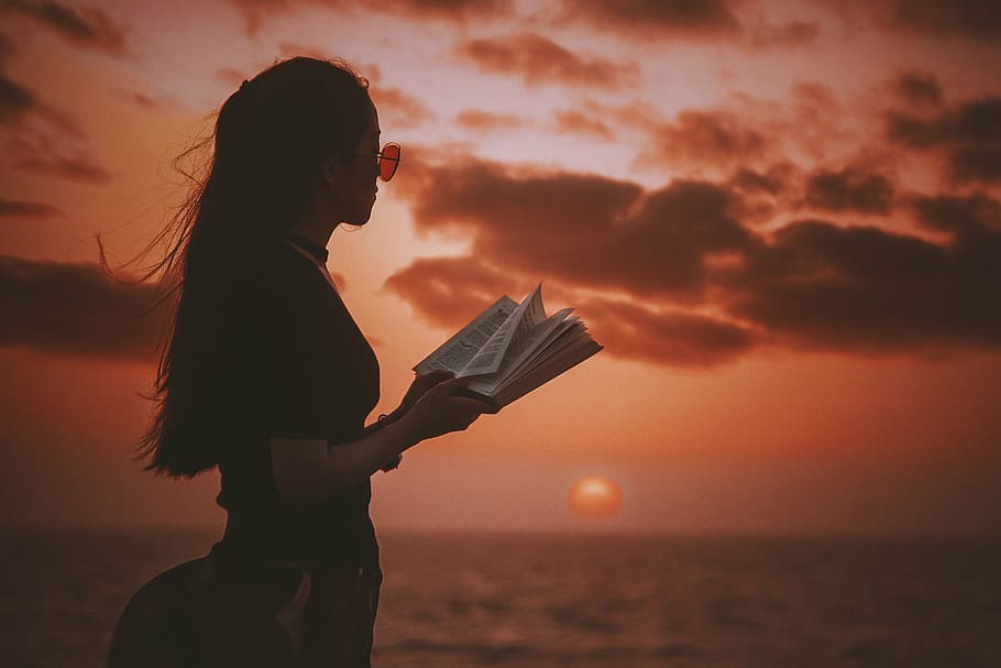 selective, focus photo, woman, holding, book, golden, hour, sea, ocean, clouds