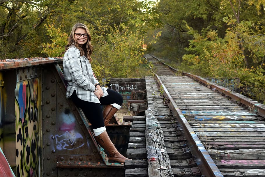 woman, gray, white, plaid, dress shirt, leaning, metal train rail road, senior photos, girl, high school