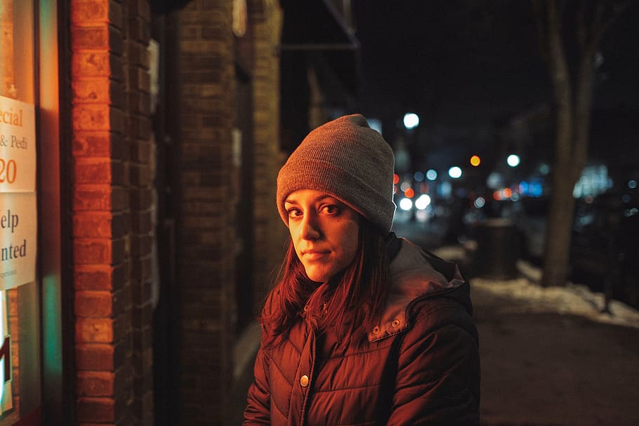 woman, standing, outside, store, nighttime, people, cold, weather, jacket, bonnet