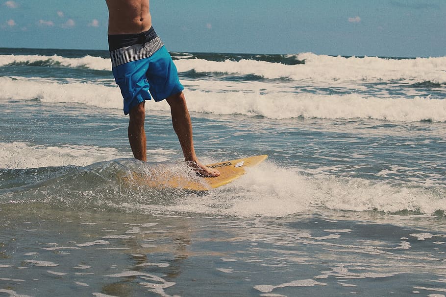 man, blue, board shorts, riding, yellow, skimboard, beach, blue board, on the beach, surfboard