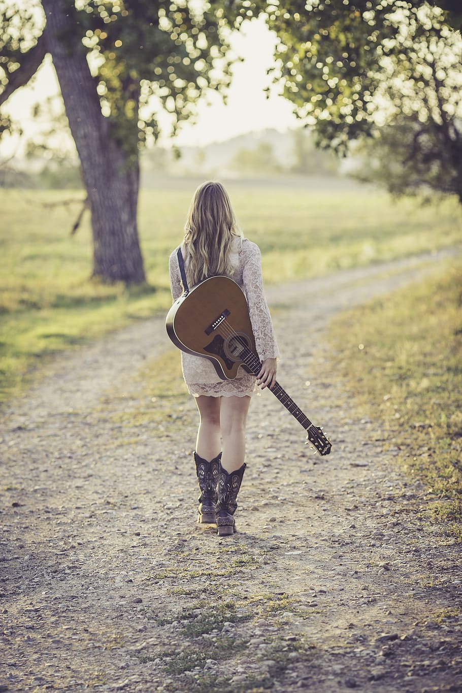 walking, woman, holding, brown, guitar, daytime, country road, young, female, musician