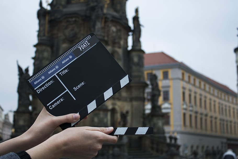 person, holding, black, white, clapperboard, outdoors, valve, movie, camera, action