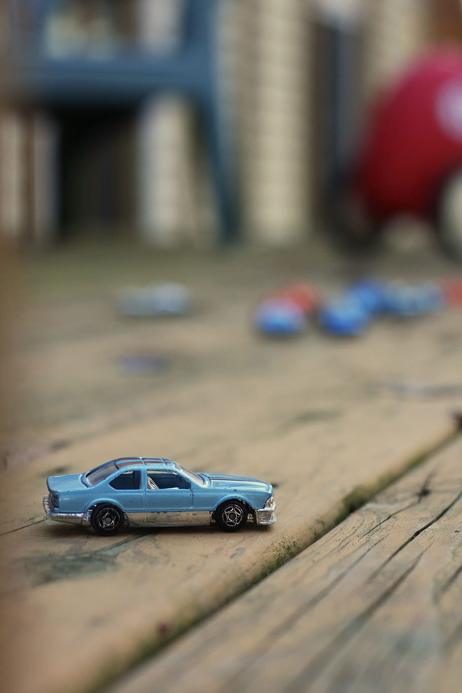 selective, focus photography, blue, coupe scale model, brown, wooden, surface, matchbox car, toy, car