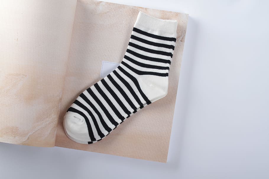 pair, white-and-black socks, brown, paper, sock, black, stripes, woman, indoors, striped