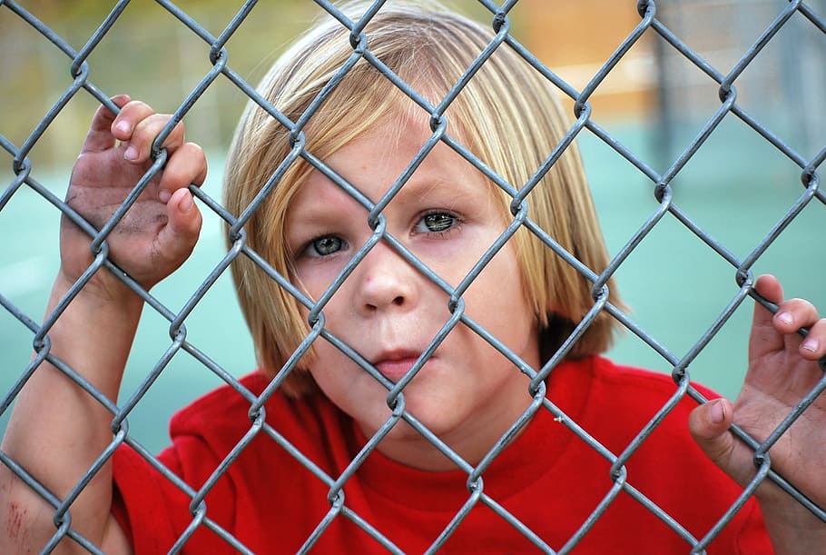 boy', wearing, red, shirt, boy, looking, fence, chain link, young, child
