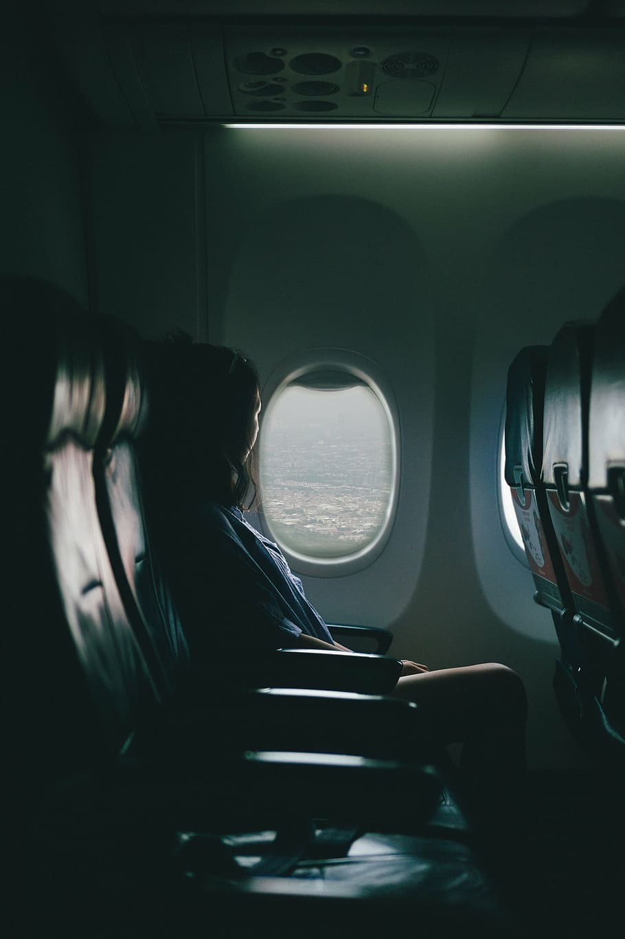 woman, sitting, inside, airplane, looking, outside, plane, near, window, watching