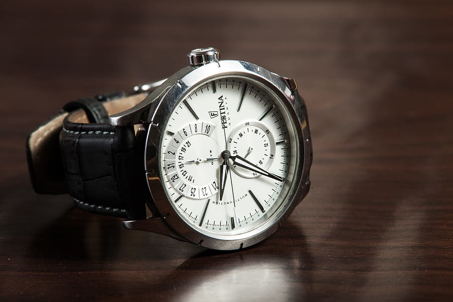 round silver-colored, framed, chronograph, watch, black, leather, strap, brown, wooden, surface