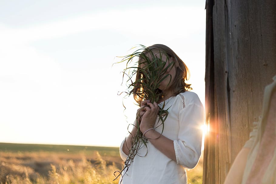 woman, covering, face, using, plant, white, shirt, holding, brown, wooden