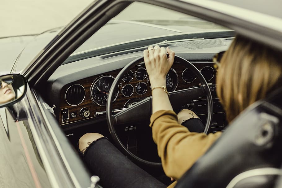 person, sits, holds, vehicle steering wheel, automotive, car, dashboard, driver, speedometer, steering wheel