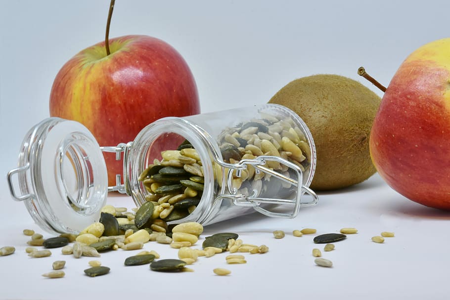 two red apples, apple, sunflower seeds, pumpkin seeds, pine nuts, fruit, food, healthy, glass, nutrition