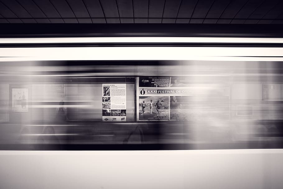 black and white, subway, station, signs, bulletin, headline, public transportation, motion, blurred motion, train