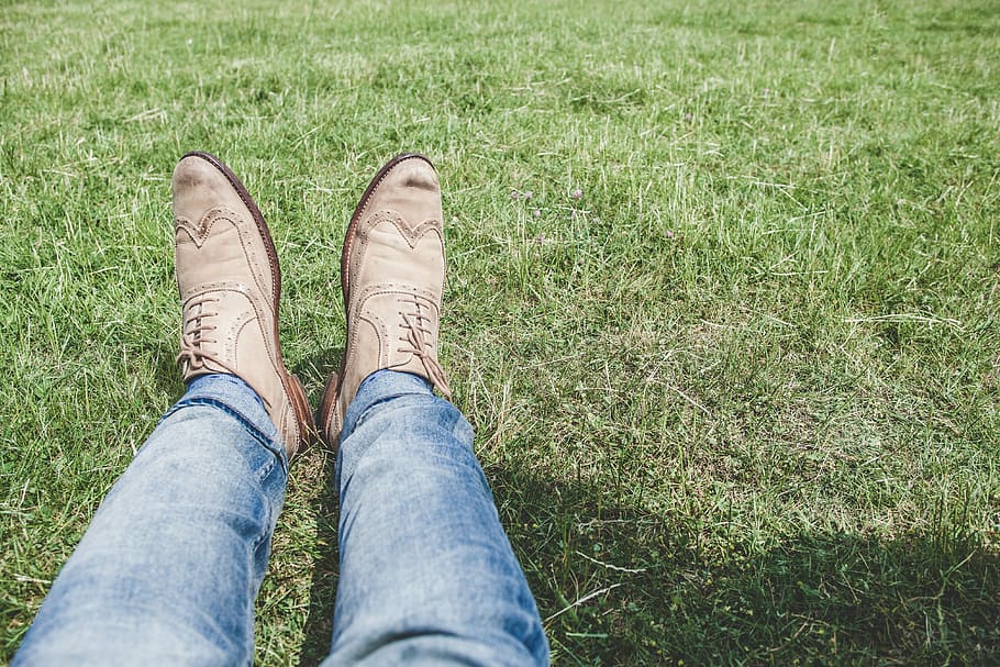 person, feet, lying, grass, wearing, blue, jean, brow, leather, wingtip