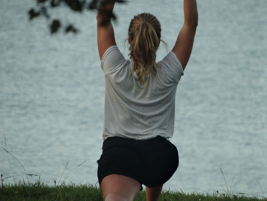 mujer, levantando, manos, hacia arriba, cuerpo, agua, deporte, bendiga, pilates, al aire libre