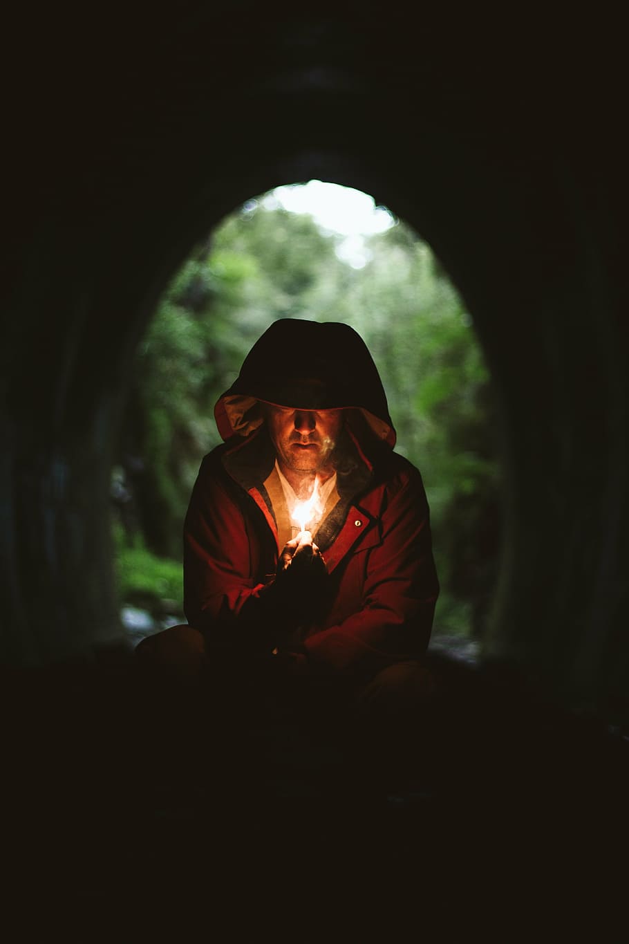 man, lighten, fire, inside, cave, red, hooded, jacket, holding, light