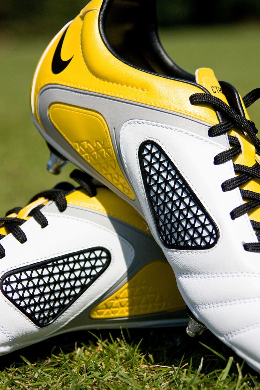 pair, white-and-yellow nike cleats, football, boots, shoes, sport, field, grass, park, team