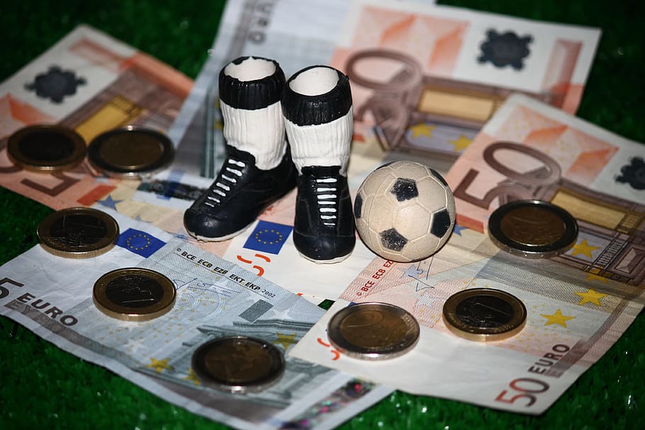 botas brancas e pretas, ao lado, bola de futebol, miniatura, futebol, dinheiro, comercial, esporte, suborno, comercialização
