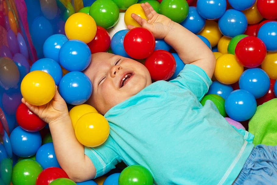 smiling, toddler, wearing, blue, t-shirt, lying, assorted-color balls, baby, ball, balls