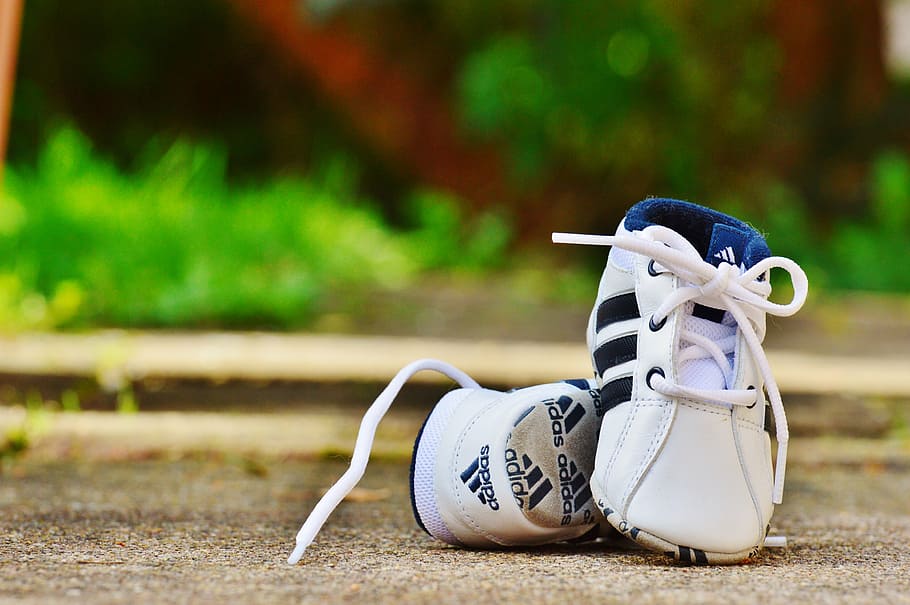 seletiva, fotografia de foco, par, criança, tênis branco e preto da adidas, terreno, sapatos de bebê, calçados esportivos, adidas, bebê