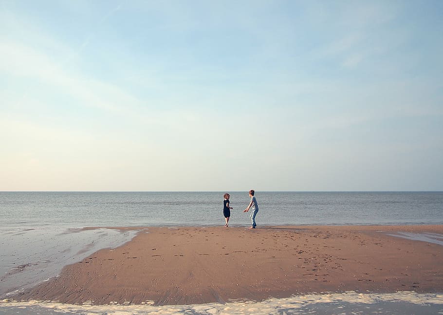 Dos, niños, jugando, orilla del mar, claro, azul, cielo, hombre, gris, camiseta