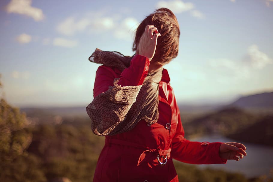 mulher, vestindo, vermelho, casaco de couro, marrom, cachecol, arranhando, cabeça, seletivo, fotografia de foco